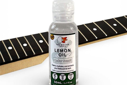 Fretboard conditioner next to a rosewood guitar neck, from our guide on how to clean a guitar