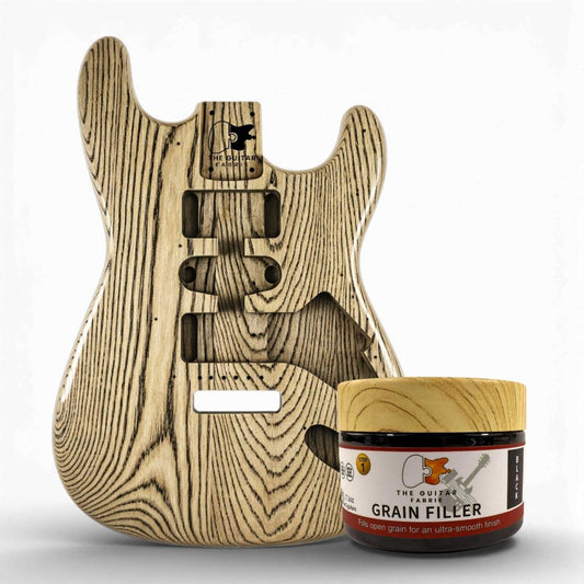 Black Grain Filler 200g jar with wooden lid displayed next to ash wood guitar body showing open grain pores.