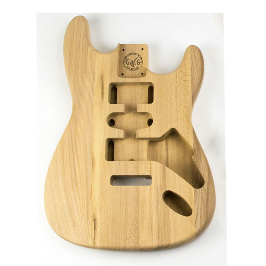 ST Ash guitar body front view showing routed cavities for pickups, bridge, and electronics on natural ash wood