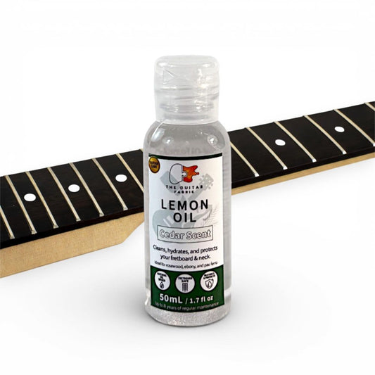 Lemon Oil Cedar Scent fretboard oil 50ml bottle displayed next to rosewood guitar fretboard