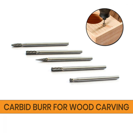 Five tungsten carbid burrs in cylinder, ball, cone, flame, and rounded cylinder shapes laid out flat