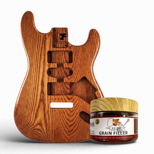 Mahogany Grain Filler 200g jar displayed beside mahogany guitar body showing grain and pore detail