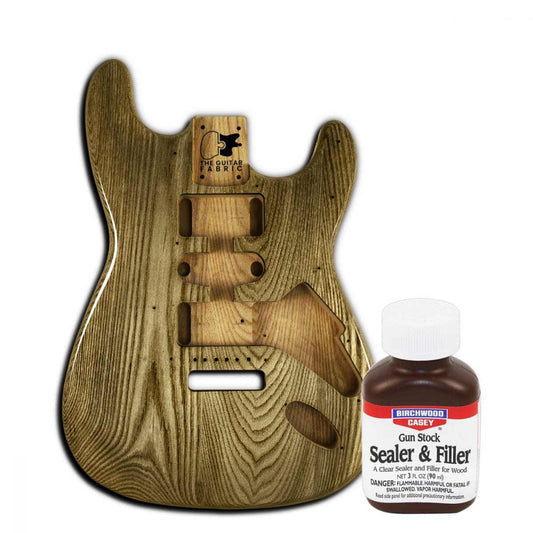 Clear Sealer & Filler basecoat bottle displayed next to unfinished guitar body showing wood grain texture